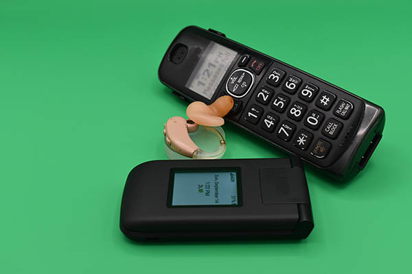 phones with BTE cellphone and portable phone beside hearing aid
