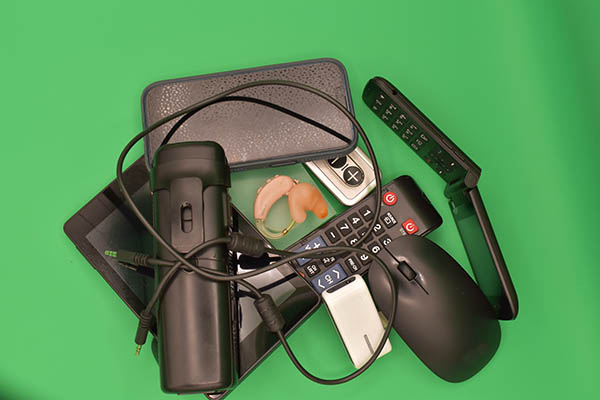technology devices around BTE pile of electronic devices surrounding a hearing aid