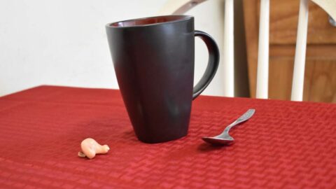 Coffee mug and spoon with hearing aid with battery door open